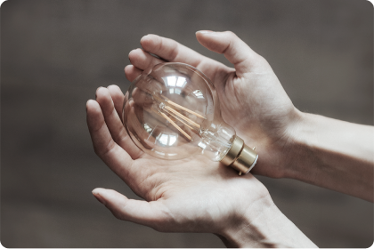 unlitted bulb resting comfortably on a pair of nurturing hands